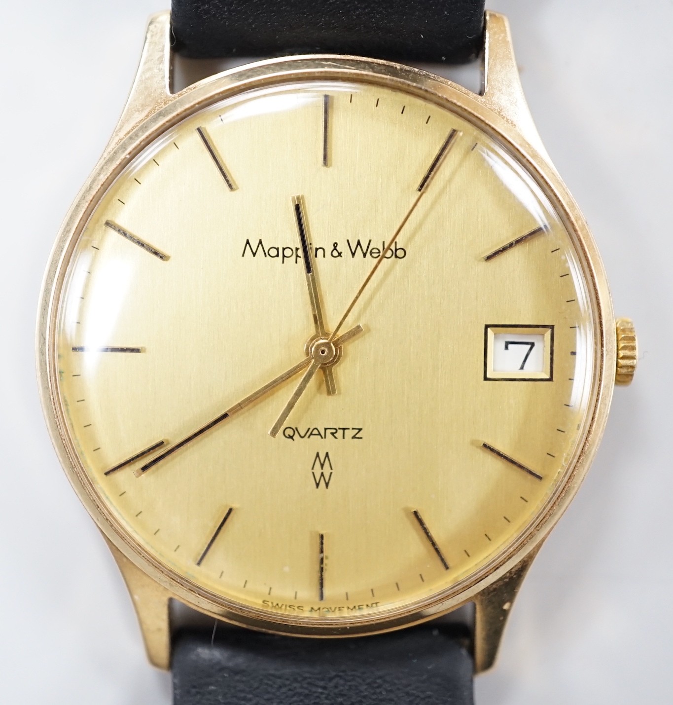 A gentleman's yellow metal quartz dress wrist watch, retailed by Mappin & Webb, with date aperture, case diameter 34mm, on a leather strap.